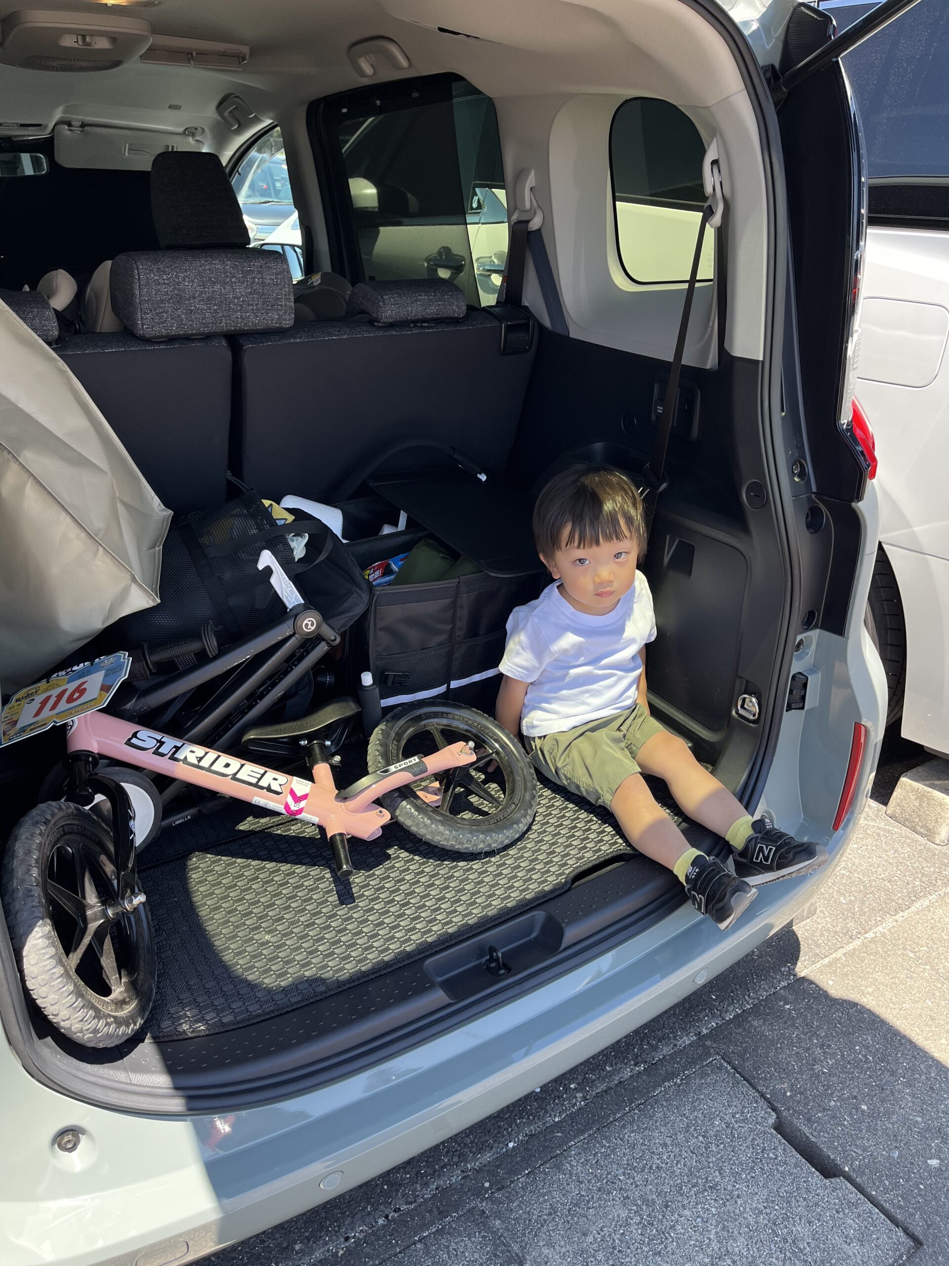 車のラゲッジスペースで座る息子